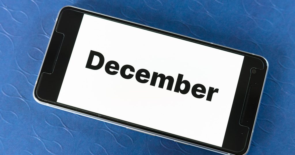 青い布の上のスマートフォンに表示された「December」の文字