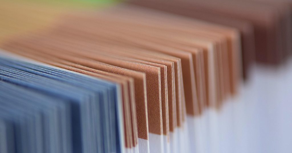 青と茶色の書類フォルダーが並んだ様子